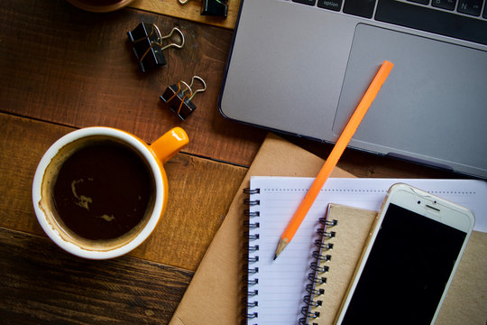 Desk work coffee cup and laptop notebook pen on wooden table
