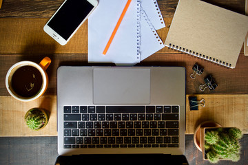 Desk work coffee cup and laptop notebook pen on wooden table