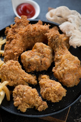 Closeup of fried breaded chicken on a metal tray, selective focus, vertical shot