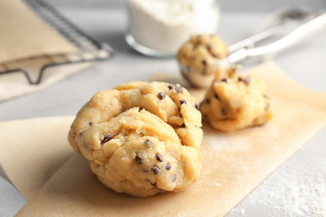 Raw cookie dough with chocolate chips on table, closeup