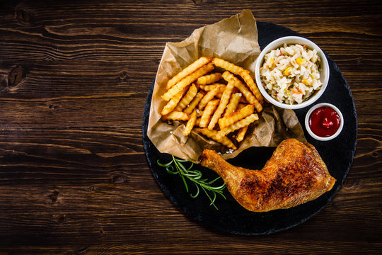 Roast chicken leg with chips and vegetables 