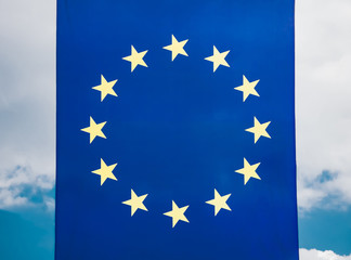 flag of the European Union developing in the wind against the sky with clouds