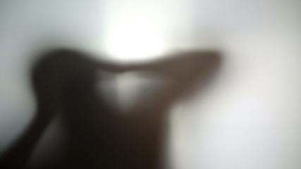 Strange dark silhouette holding head in hands, hallucinations, desperate person