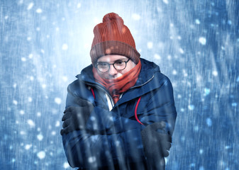 Handsome young boy shivering and trembling at snowstorm concept
