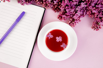 Cup of tea, diary and bouquet  lilac