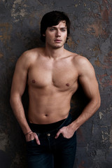 Obraz na płótnie Canvas Handsome man shows athletic naked muscular body.