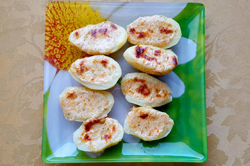 Potatoes baked in an oven with cheese and spices on a plate.