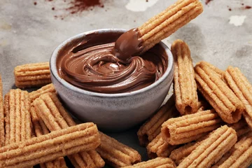 Gordijnen Traditional Spanish dessert churros with sugar and chocolate © beats_