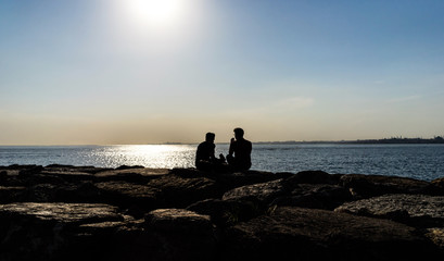 Silhouette of people against the sea.