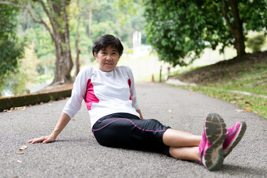 Senior Asian woman is resting after a jogging or running