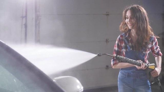 Woman Washing car with high pressure blaster