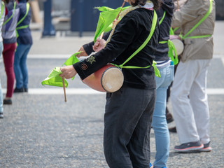 Woman playing drum on a Japanese taiko in a street performance