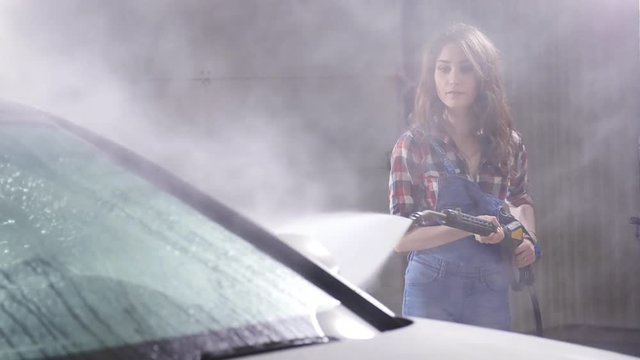 Woman Washing car with high pressure blaster
