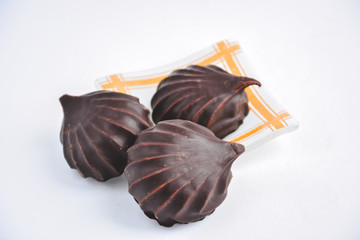 a few marshmallows in chocolate on a transparent dish on a light background
