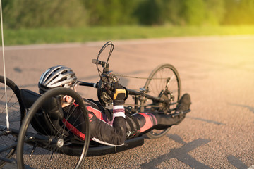 Cyclist on the handbike in maximum effort at a special bicycle road under the evening sunset in summer