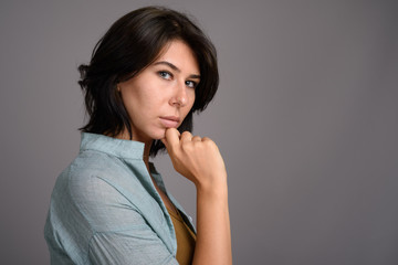 Obraz premium Young beautiful woman against gray background