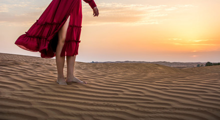 Woman standing in the desert with sunset view