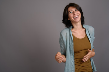 Obraz premium Young beautiful woman against gray background