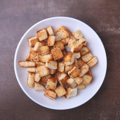 Delicious crispy croutons, crumbs of bread in white plate. ready for cooking.