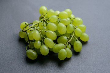 Green grapes on dark background. Selective focus with shallow depth of field.