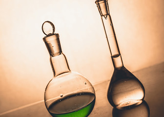 laboratory glassware with liquids. yellow background.