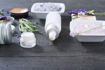 beauty products and lavender on black wooden table