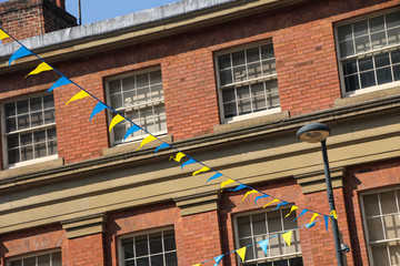 Yellow and blue bunting against a red brick building