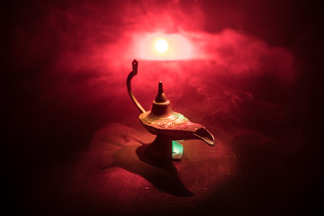 Antique Aladdin arabian nights genie style oil lamp with soft light white smoke, Dark background....