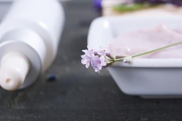 beauty products and lavender on black wooden table
