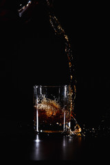 a glass of whiskey, rum or alcohol  on a dark background