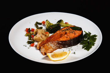 Dish of fish (trout) on a dark background