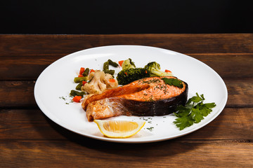 Dish of fish (trout) on a dark background