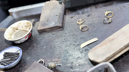 Goldsmith's bench with some golden rings in process - selectived focus