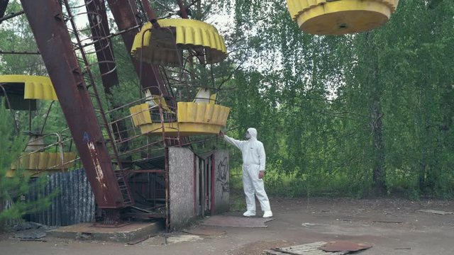 Man using a geiger counter with gas mask and protective suit in Pripyat. Slider shot - Juni 2017: 30km Chernobyl, exclusion zone