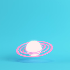 Pink abstract glowing planet with rings on bright blue background in pastel colors