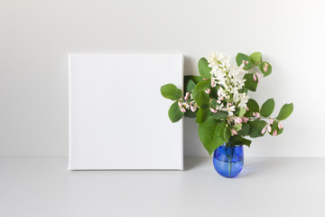 Mockup poster in neutral interior. White square canvas and bouquet of flowers.