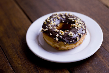 Choco Donut on a white plate and a wooden table 