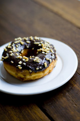 Choco Donut on a white plate and a wooden table 