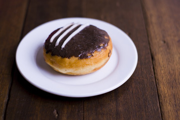 Choco Donut on a white plate and a wooden table 