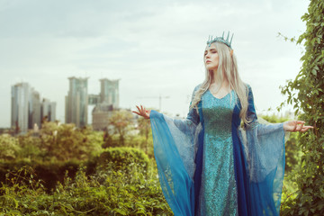 Fairy woman elf in a fairy forest on the background of the city.