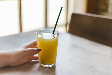 Woman hand holds glass of juice.