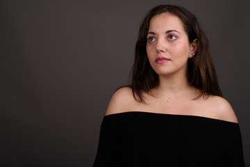 Naklejka premium Young beautiful woman wearing black off-shoulder top against gra