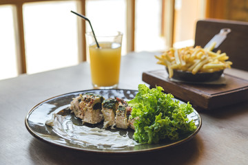 Meat with sauce and a glass of orange juice
