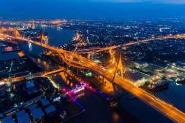 Fototapeta na wymiar Aerial view of Bhumibol suspension bridge in Bangkok city with light trails of car on the road at sunset sky and clouds in Bangkok Thailand.