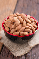 Almond nut in a ceramic bowl against wooden table