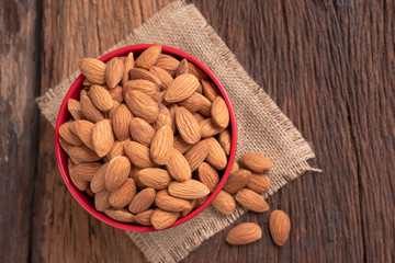 Almond nut in a ceramic bowl against wooden table