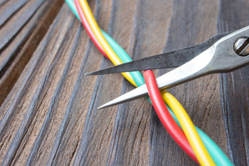 Dismantling electronic bomb, tongs cut the red wire on a bunch of colored wires