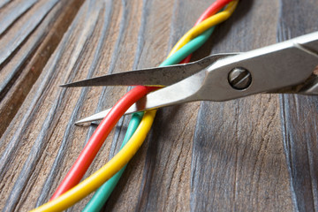 Dismantling electronic bomb, tongs cut the red wire on a bunch of colored wires