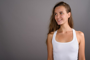Obraz premium Young beautiful woman with long blond hair against gray backgrou