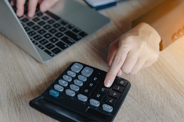 Business financial manager using calculator and laptop for analyzing finance graph data in office. successful concept.